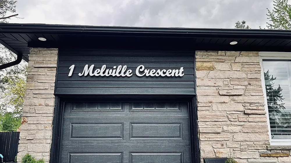 1 Melville Crescent in white script above a stone entryway