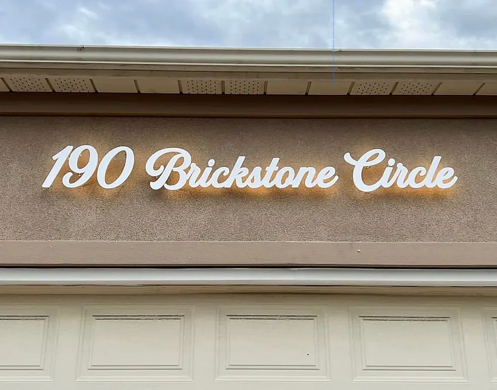 190 Brickstone Circle in white script, backlit above a garage