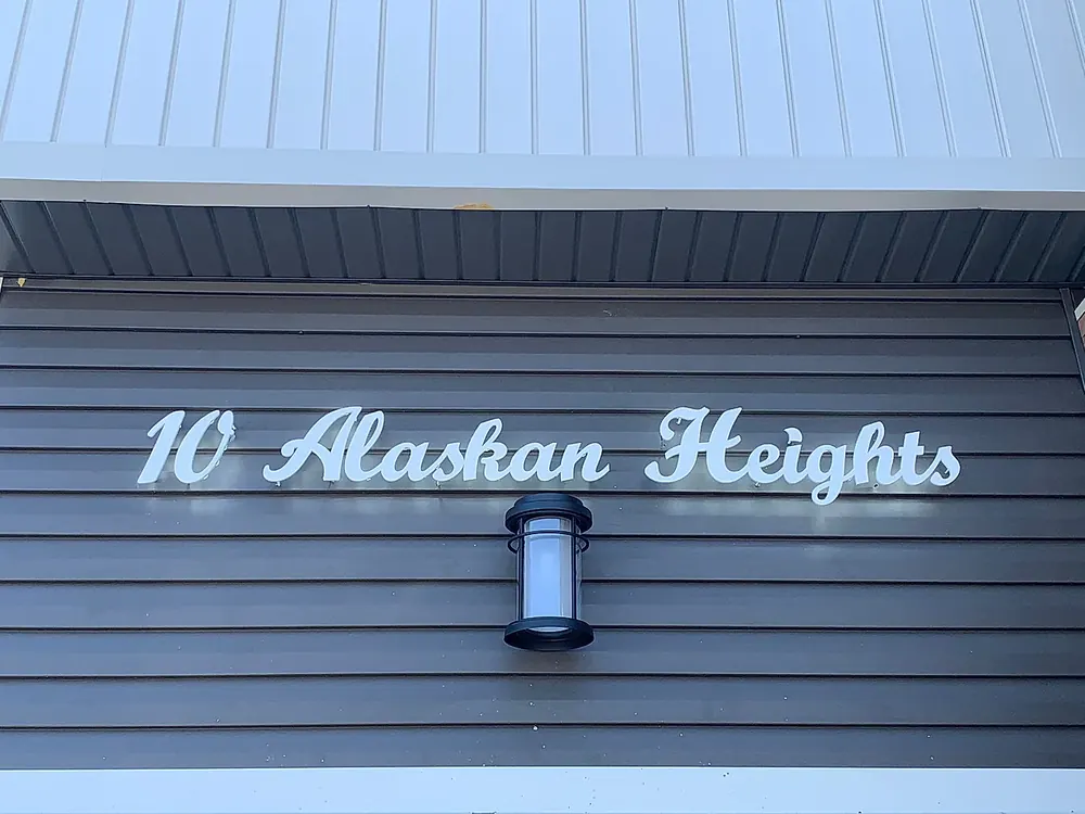 10 Alaskan Heights in matte white script on grey siding