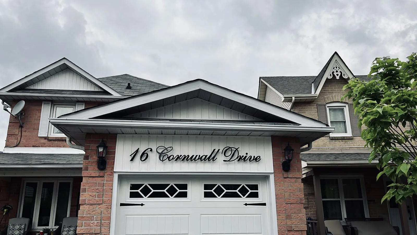 16 Cornwall Drive in matte black script on a brick gable